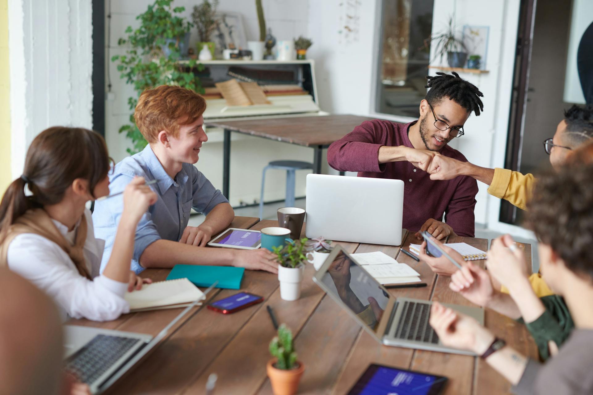 Creative web solutions team collaborating in a modern workspace, exchanging ideas and engaging in teamwork.