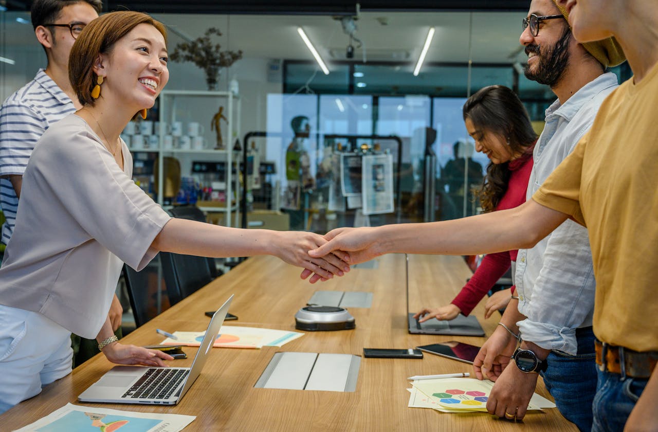 Team members shaking hands after delivering tailored digital marketing solutions, ensuring continuous collaboration.